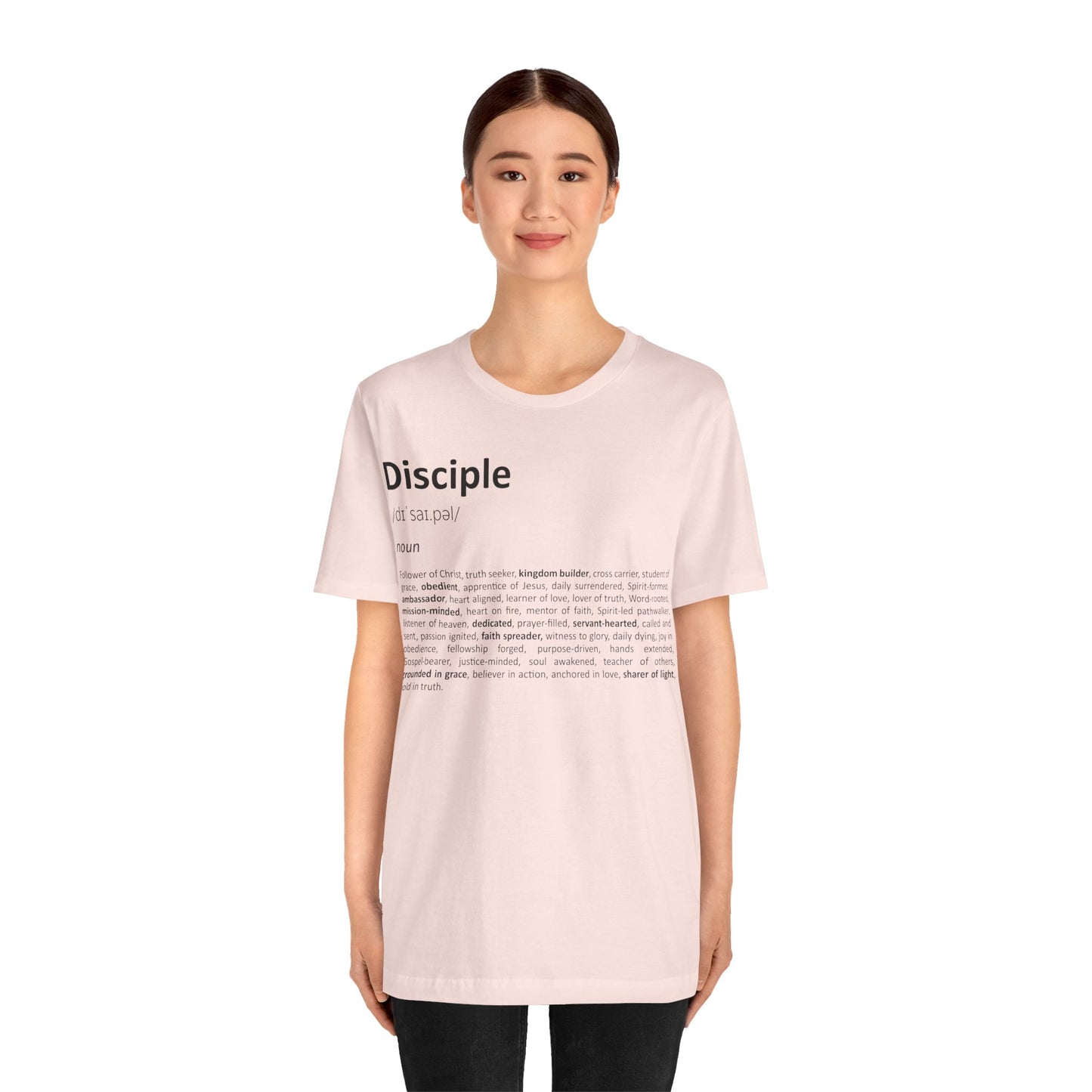 Woman wearing a light pink t-shirt with text on a white background