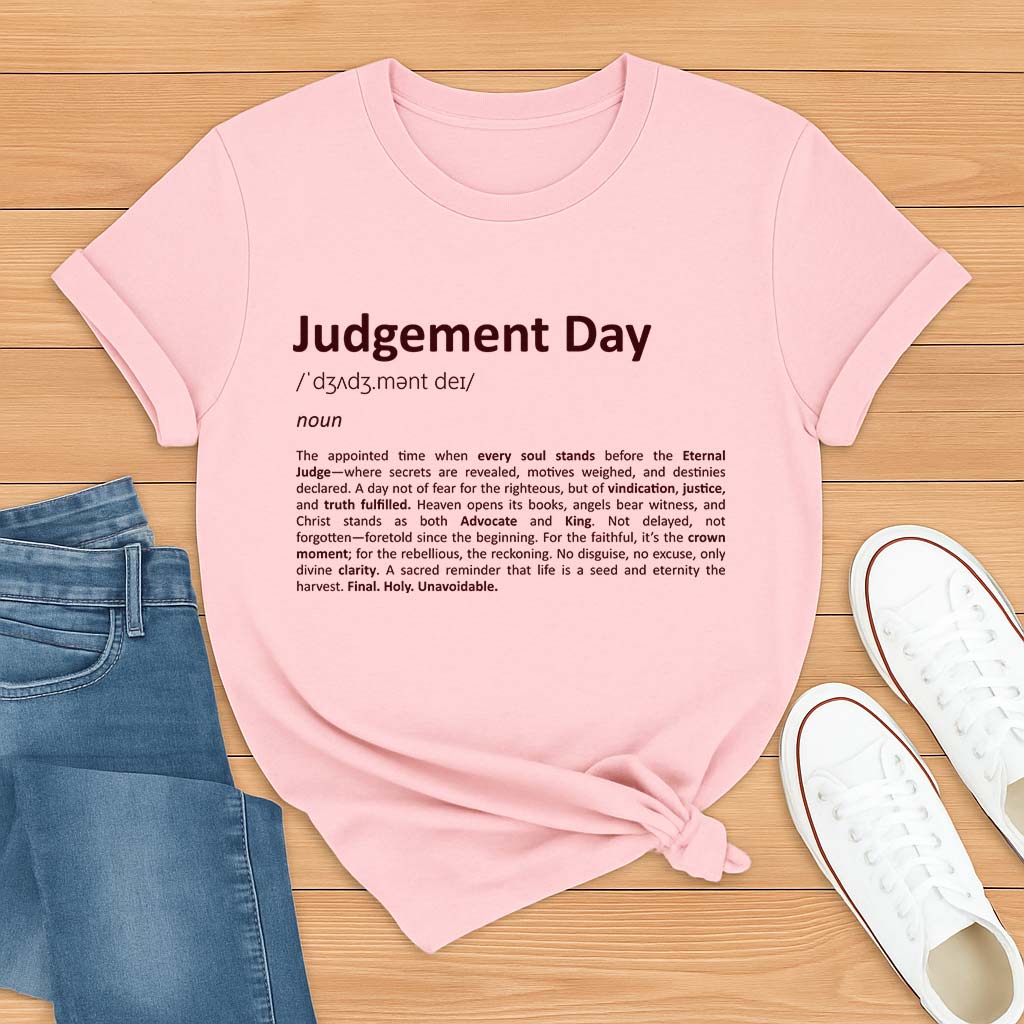 Pink t-shirt with 'Judgement Day' text on a wooden surface with jeans and shoes.
