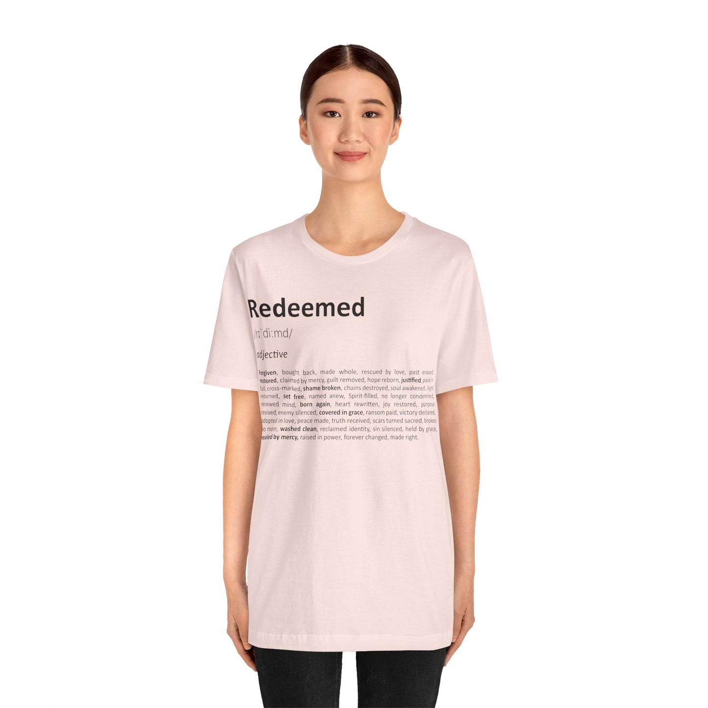 Person wearing a light pink t-shirt with text on a white background