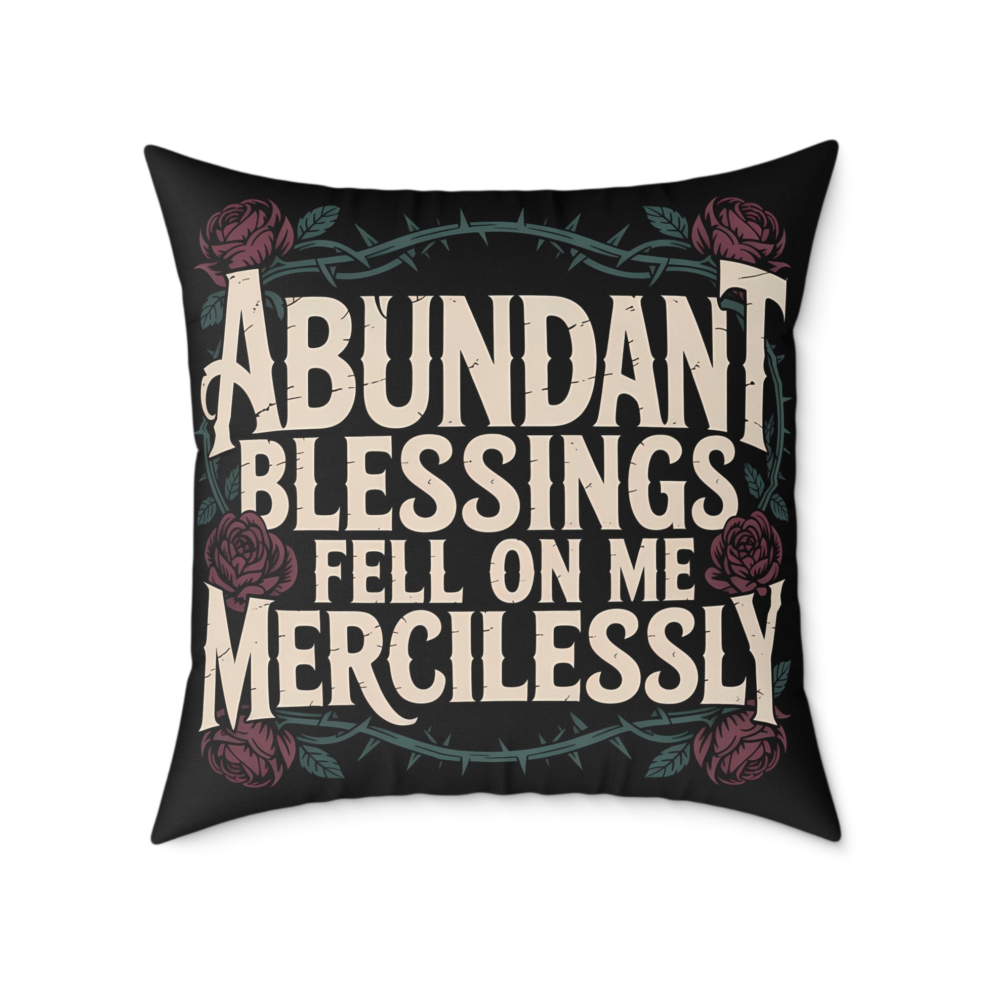 Decorative pillow with text 'Abundant Blessings Fell on Me Mercilessly' and floral design on a black background.