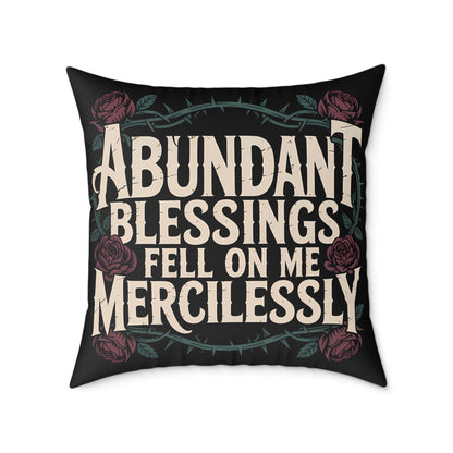 Decorative pillow with text 'Abundant Blessings Fell on Me Mercilessly' and floral design on a black background.