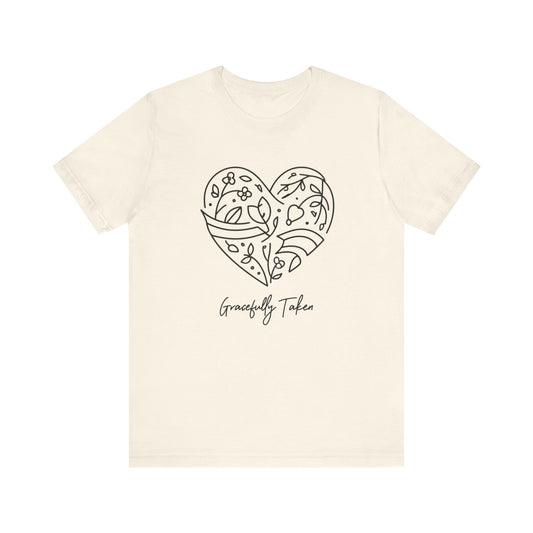 Beige t-shirt with a heart design and 'Gracefully Taken' text on a white background