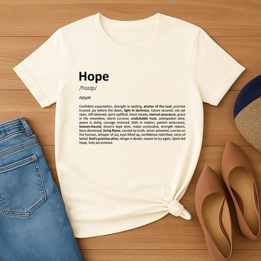 White t-shirt with 'Hope' definition text on a wooden surface with jeans and shoes.
