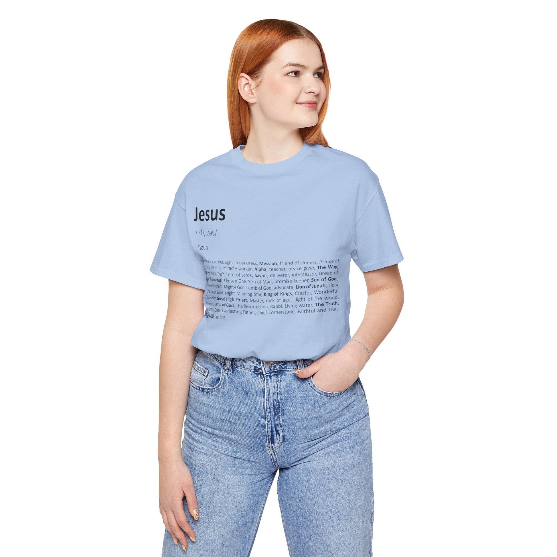 Woman wearing a light blue t-shirt with 'Jesus' printed on it, standing against a white background.