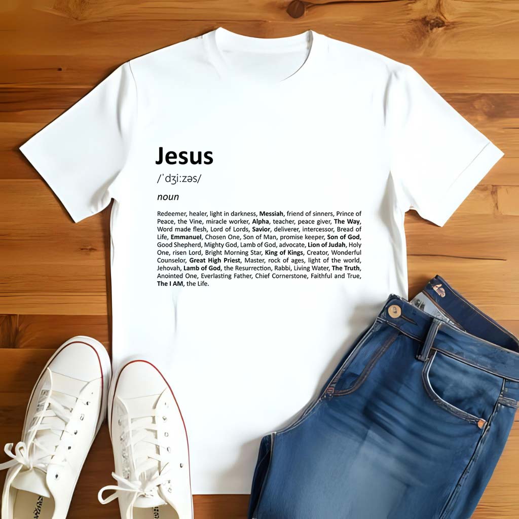White t-shirt with 'Jesus' definition print on a wooden floor with white sneakers and blue jeans.