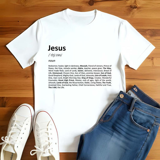 White t-shirt with 'Jesus' definition print on a wooden floor with white sneakers and blue jeans.