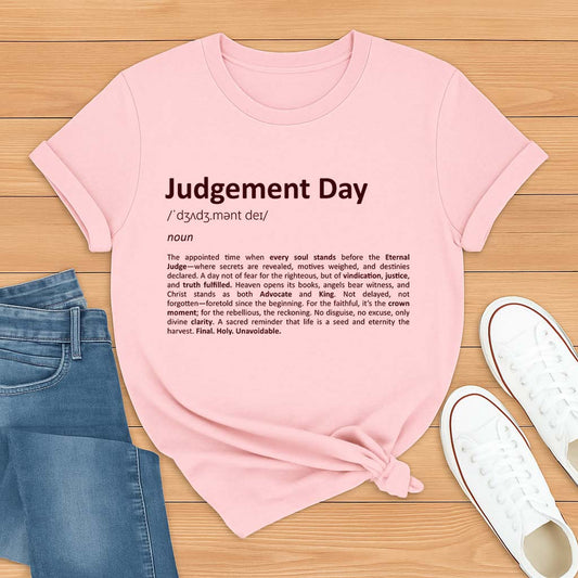 Pink t-shirt with 'Judgement Day' text on a wooden surface with jeans and shoes.