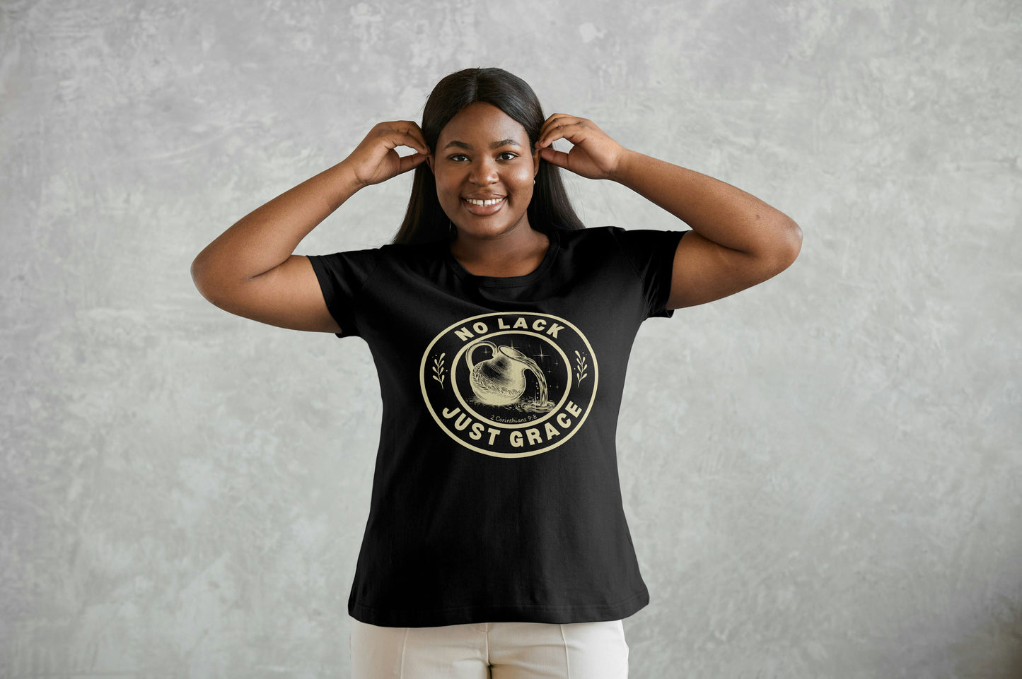 Woman wearing a black t-shirt with a graphic design and text against a gray background