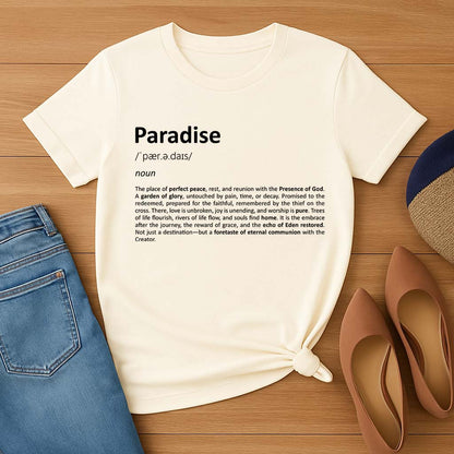 Cream t-shirt with 'Paradise' definition text on a wooden surface with jeans and shoes.
