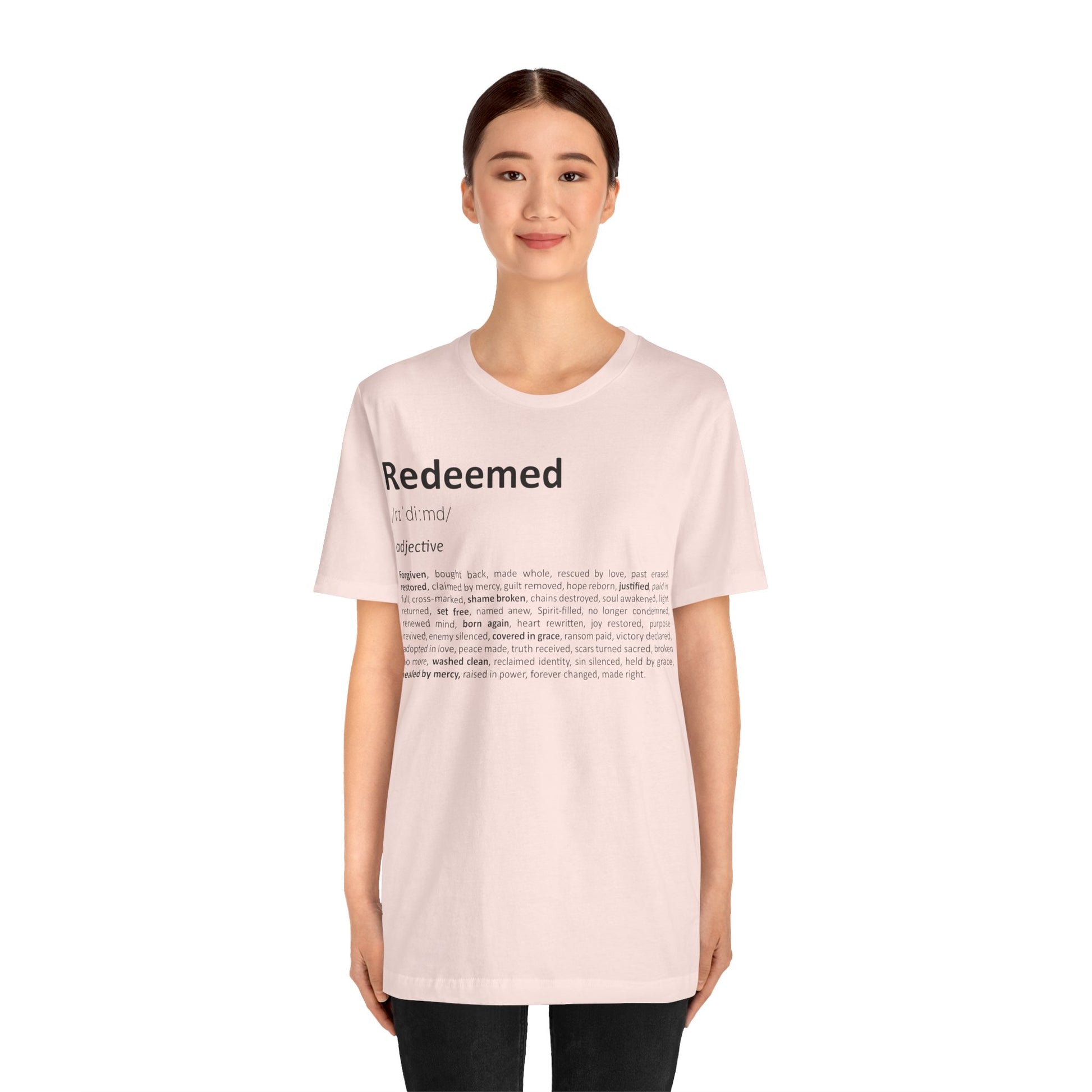 Person wearing a light pink t-shirt with text on a white background