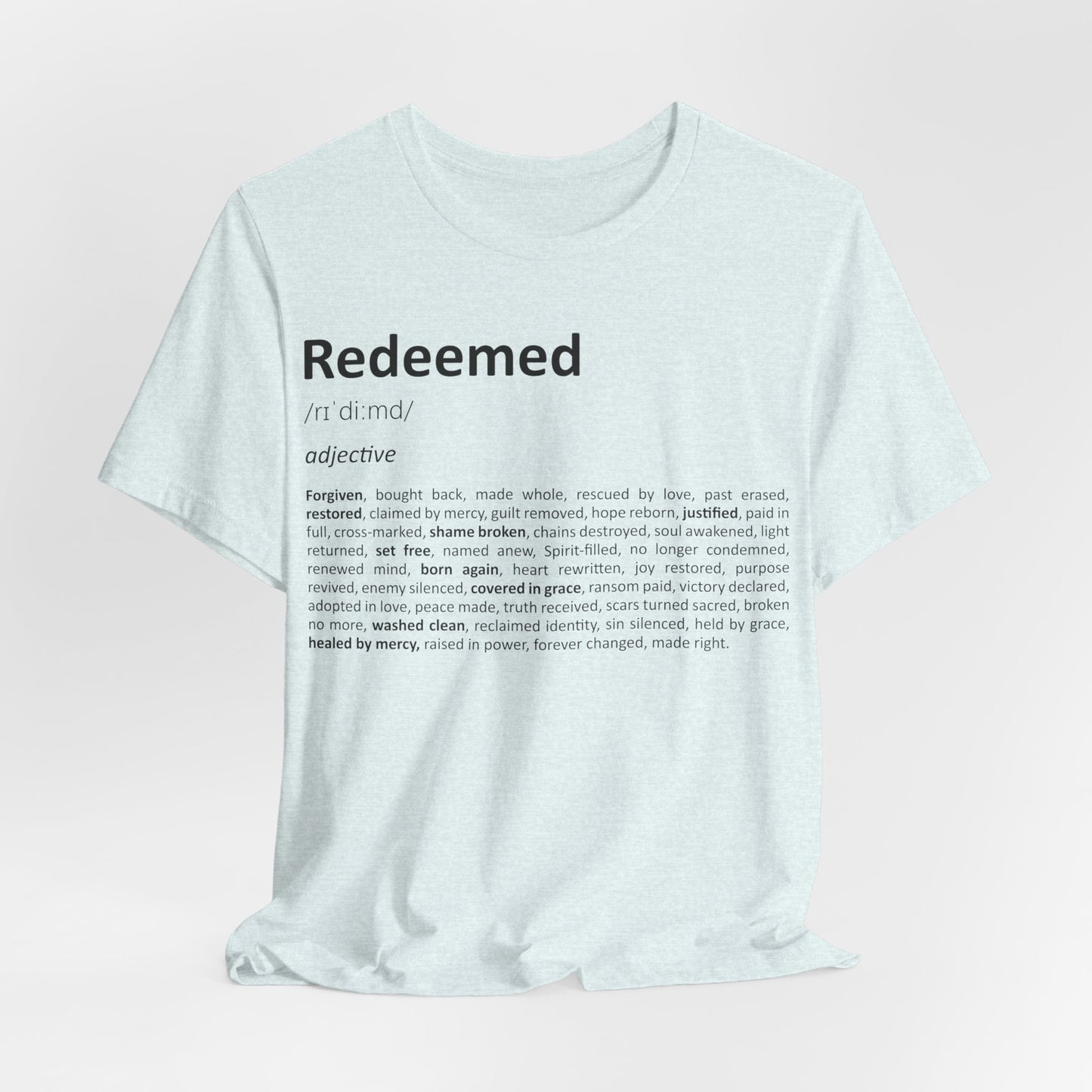 White t-shirt with 'Redeemed' definition text on a light pink background