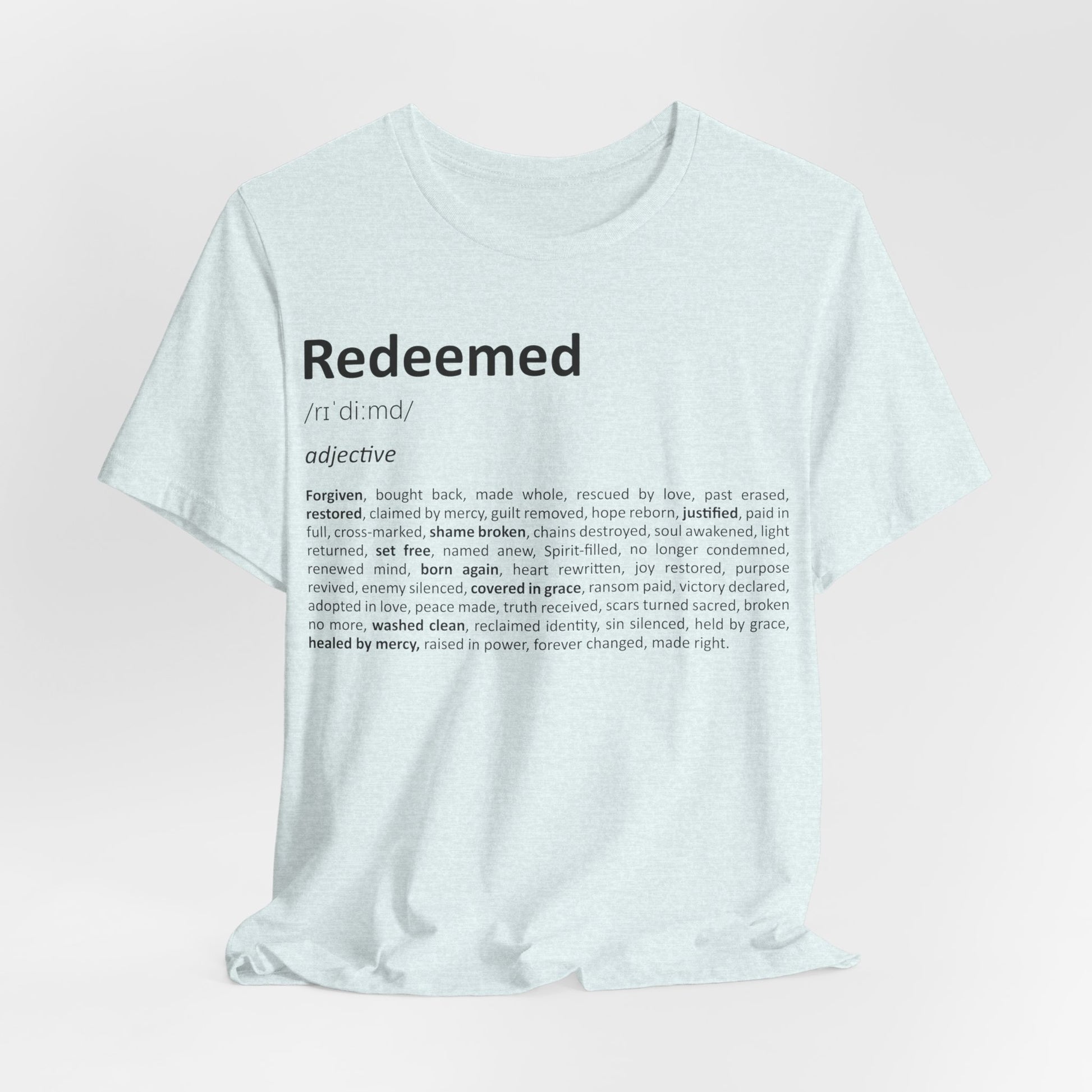 White t-shirt with 'Redeemed' definition text on a light pink background